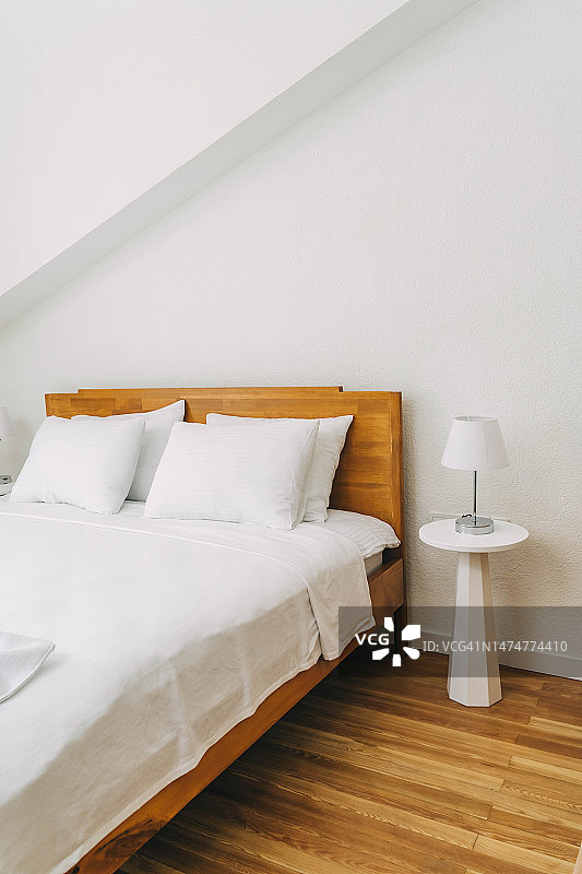 空荡荡的酒店房间，一张新铺好的白色床图片素材