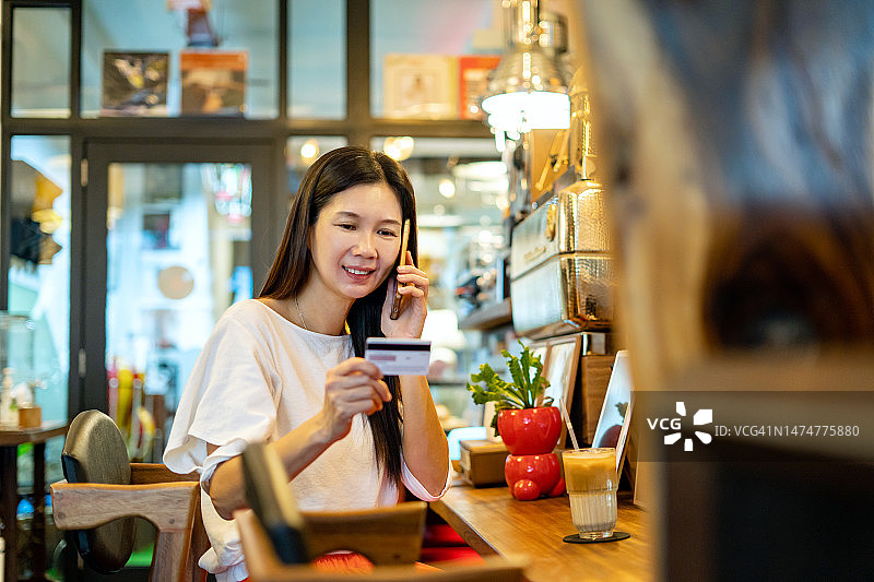 女人持有信用卡并进行在线订购图片素材