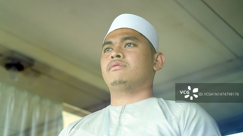 戴着宗教服饰和帽子的亚洲穆斯林男人图片素材