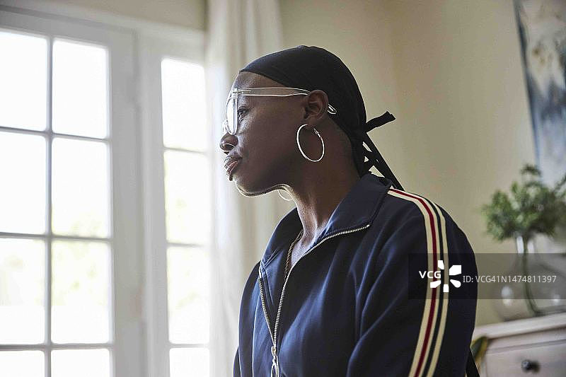 戴着头巾的女性癌症患者在家中沉思图片素材