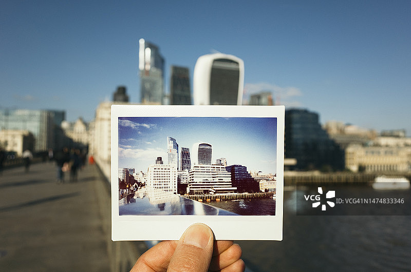男人手持伦敦金融区的即时胶片照片图片素材