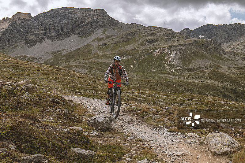 年轻女子沿山路骑山地自行车图片素材