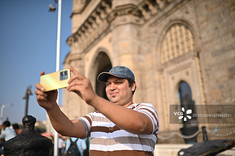 中年男游客在印度孟买的印度门附近自拍图片素材
