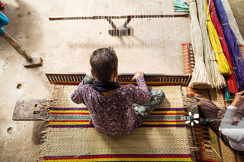 编织竹席的越南老年妇女图片素材