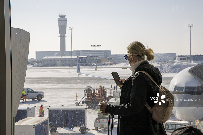 中年妇女在机场使用手机图片素材