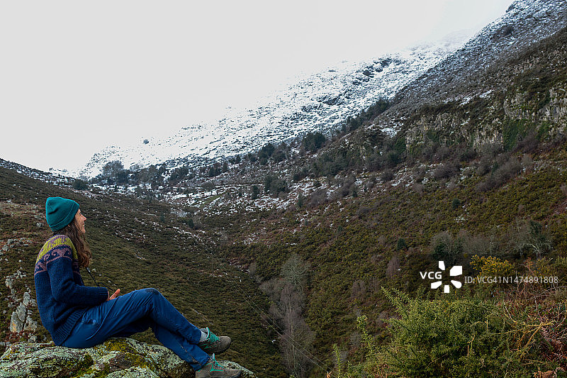 冬季山区坐在地上的徒步女子图片素材