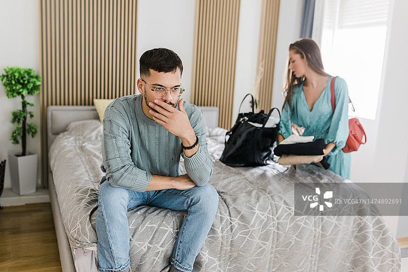 年轻夫妇关系不和，争吵后女人收拾行李离开图片素材