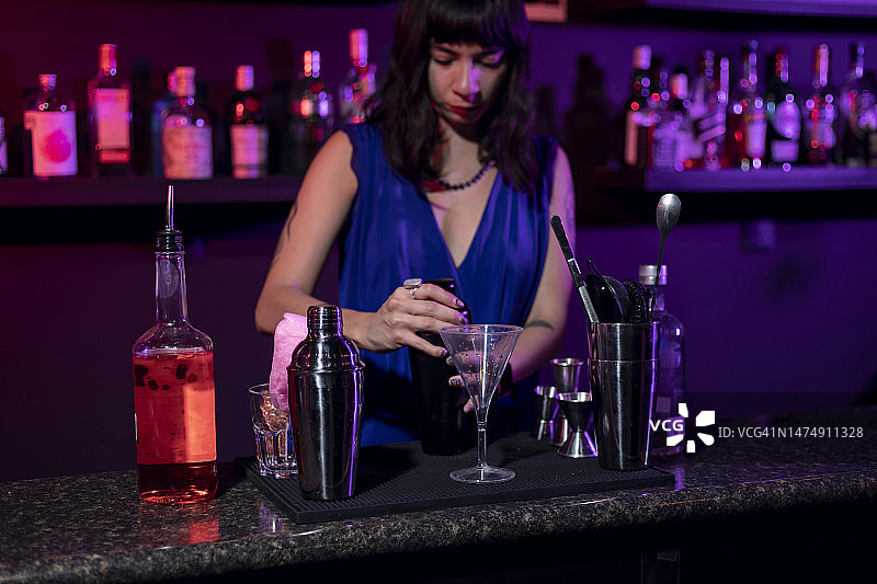 在墨西哥酒吧柜台准备鸡尾酒的女酒保图片素材