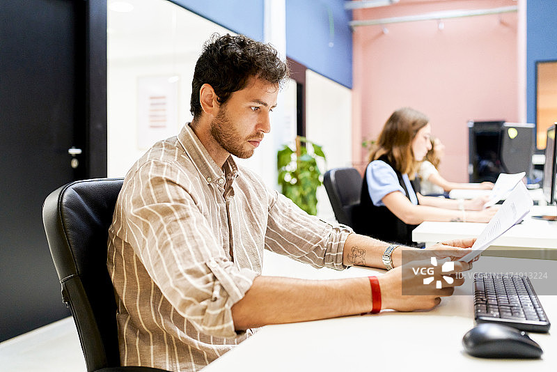 男女数据分析师在办公室使用电脑工作，专注于向系统输入信息图片素材