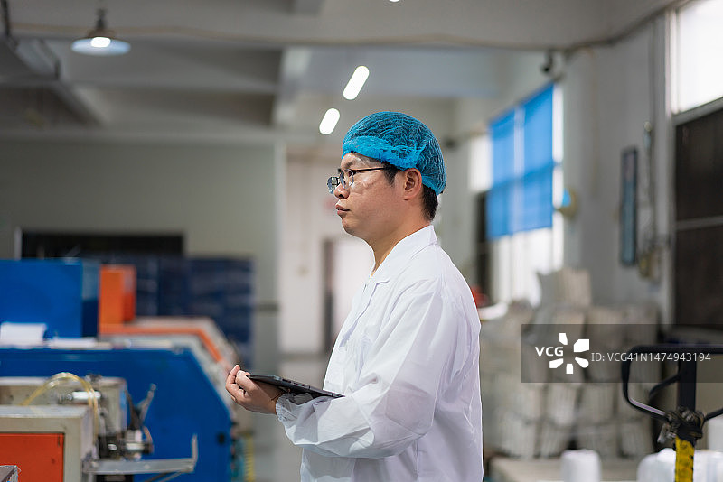 工程师在车间检查机械操作图片素材