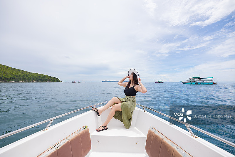 年轻的亚洲女性在游艇上度假图片素材
