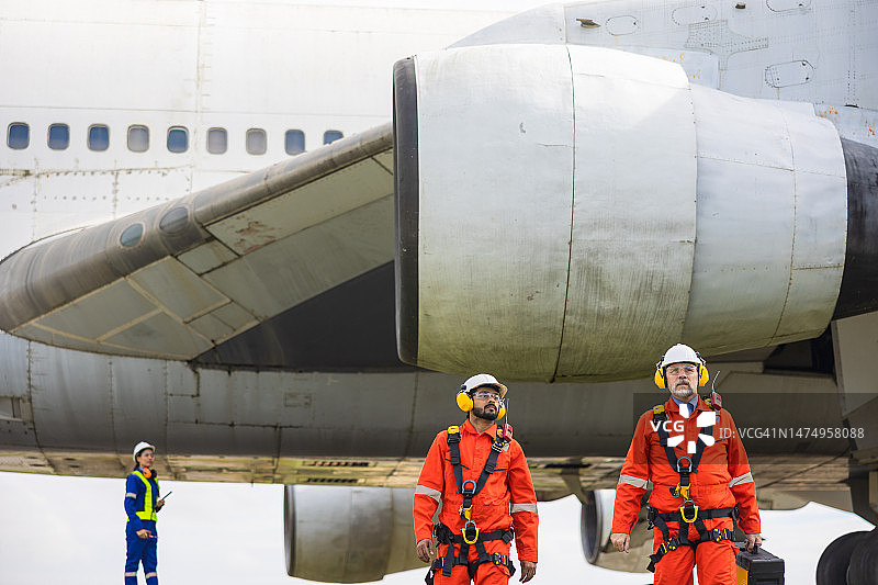 两名机械工程师正在维护飞机并修理喷气发动机图片素材