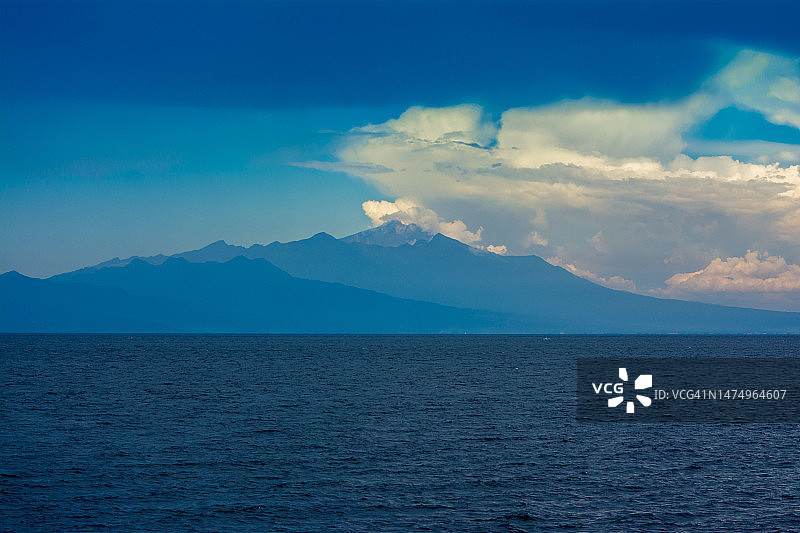 蓝色海洋上空的蓝色天空渐变山景图片素材