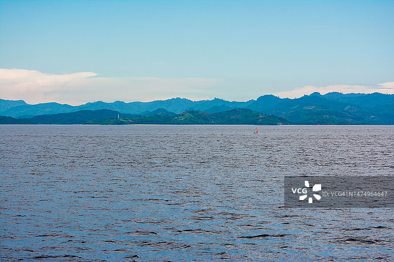蓝色海洋上空的蓝色天空渐变山景图片素材