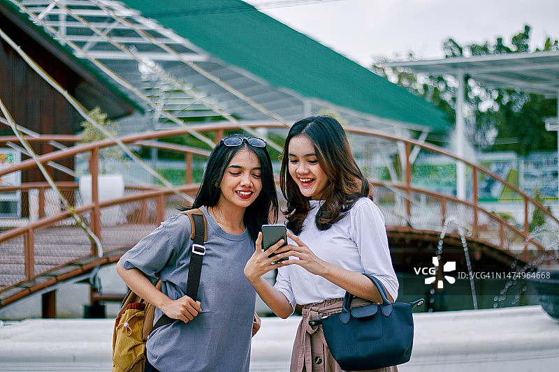 使用智能手机寻找新目的地的亚洲女性图片素材