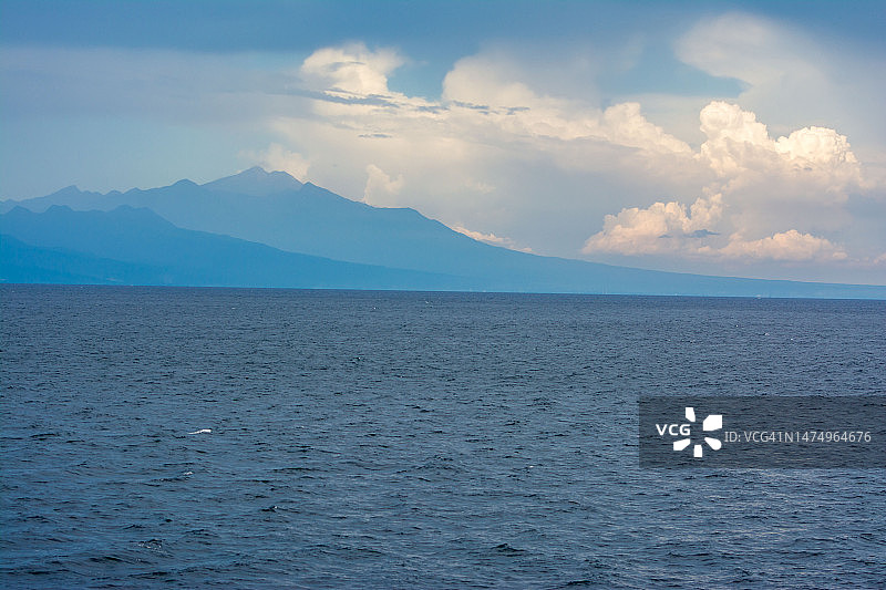 蓝色海洋上空的蓝色天空渐变山景图片素材