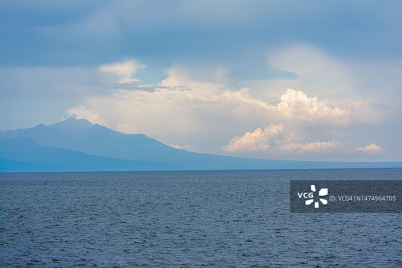 蓝色海洋上空的蓝色天空渐变山景图片素材