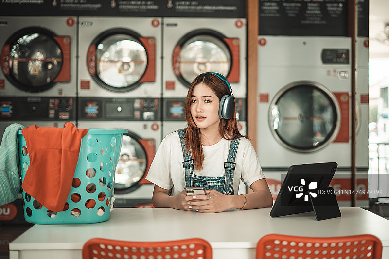 在自助洗衣店里的年轻女子图片素材