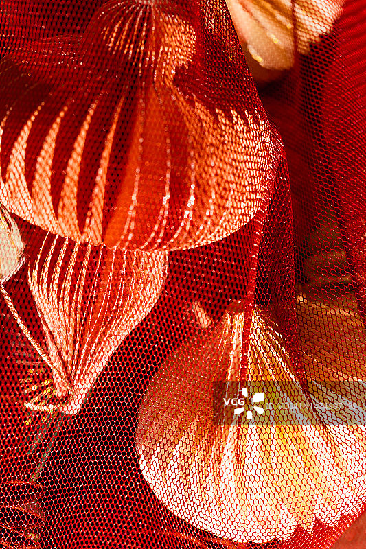 红色网袋中的纸质圣诞树装饰品图片素材