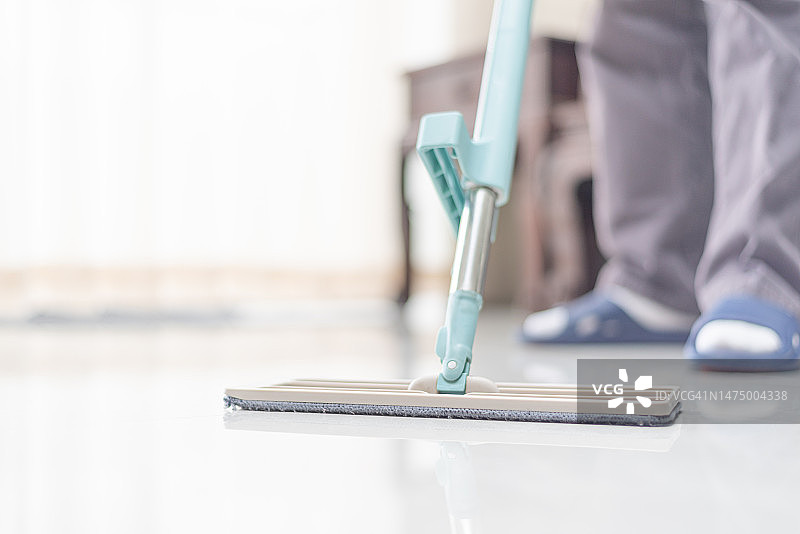 男人们在家用拖把清洁地板图片素材