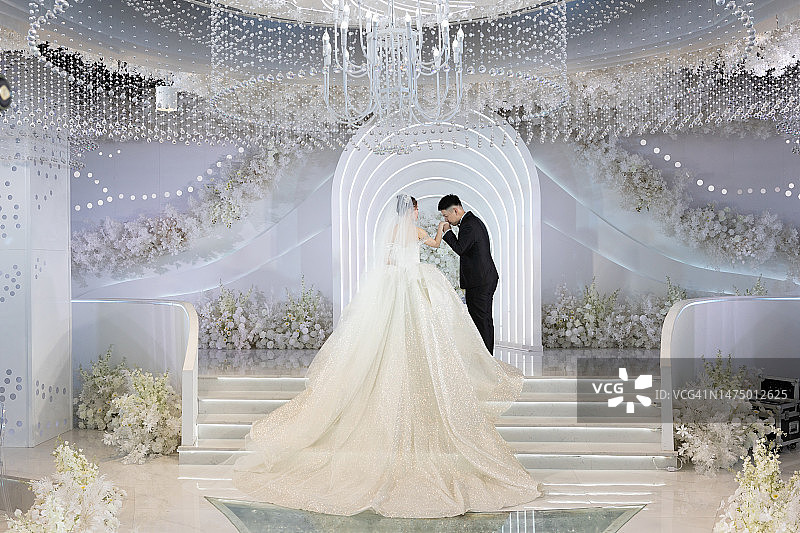 婚礼上，年轻的新郎亲吻新娘的手图片素材