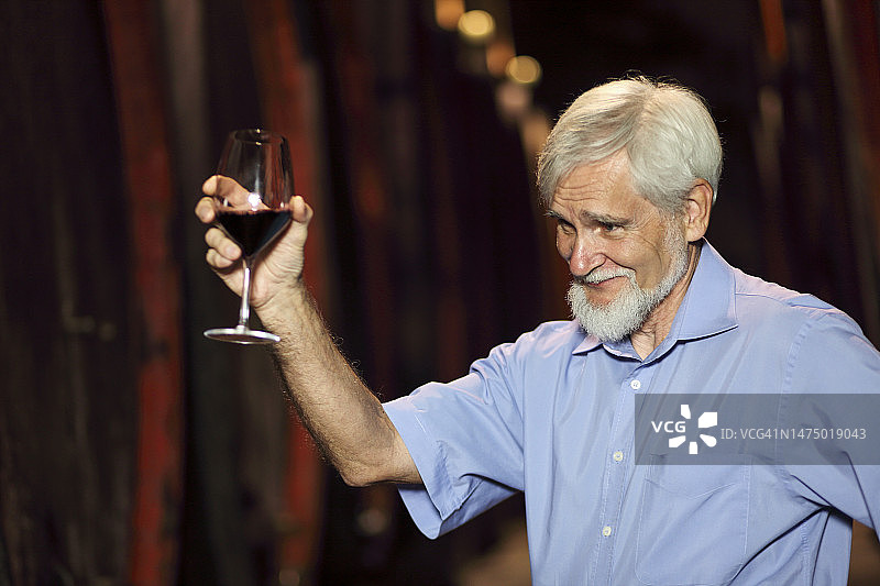 在自家酒窖里的年长农民图片素材