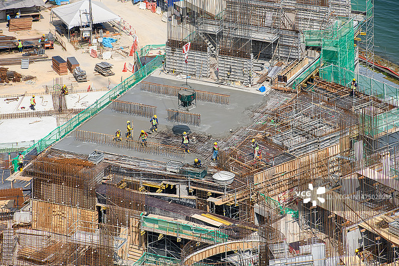 混凝土工人在高层建筑上浇筑和找平图片素材