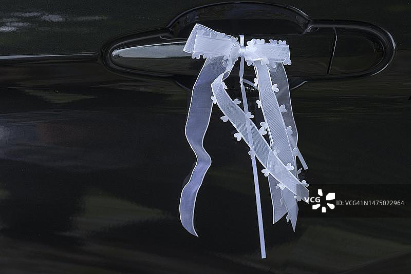 婚礼装饰：德国梅克伦堡-前波莫瑞州婚礼车的门把手上的蝴蝶结图片素材