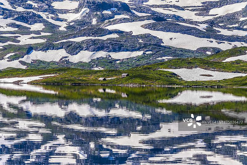 挪威哈当厄尔高原，豪克利山，斯塔瓦特恩湖中积雪山脉倒影图片素材
