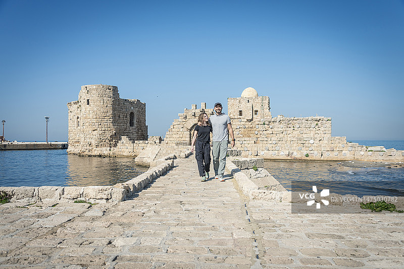 年轻情侣参观黎巴嫩西顿的海上城堡。黎巴嫩西顿十字军城堡的主闸门图片素材