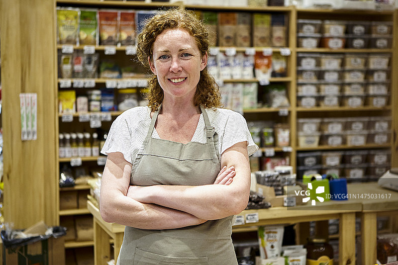 双臂交叉站在商店内的女店主 портрет图片素材