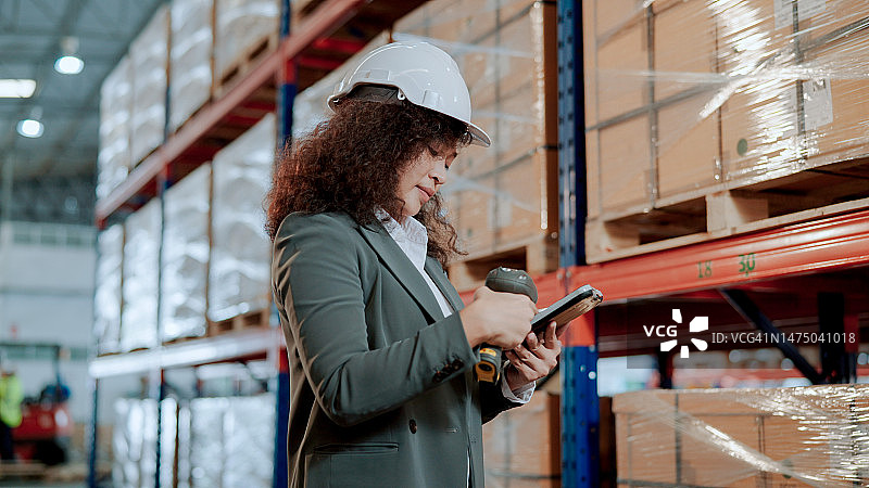 年轻的亚洲仓库检验员使用平板电脑和激光扫描仪盘点库存图片素材
