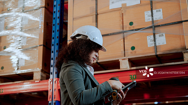 贸易公司的年轻亚洲员工使用平板电脑和条形码扫描仪清点库存图片素材