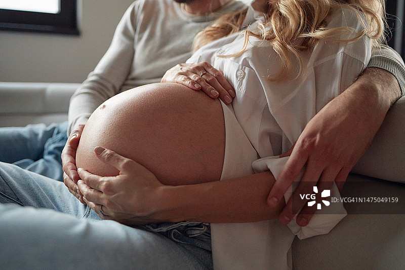 情侣拥抱孕妇腹部特写图片素材