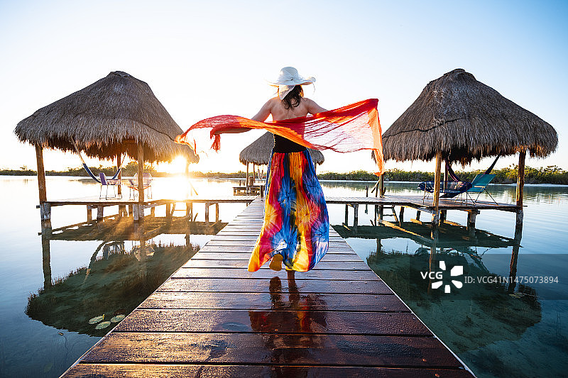 在墨西哥的码头上，女人玩着红色纱笼图片素材