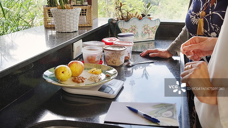 营养师与客户在厨房称量食物图片素材