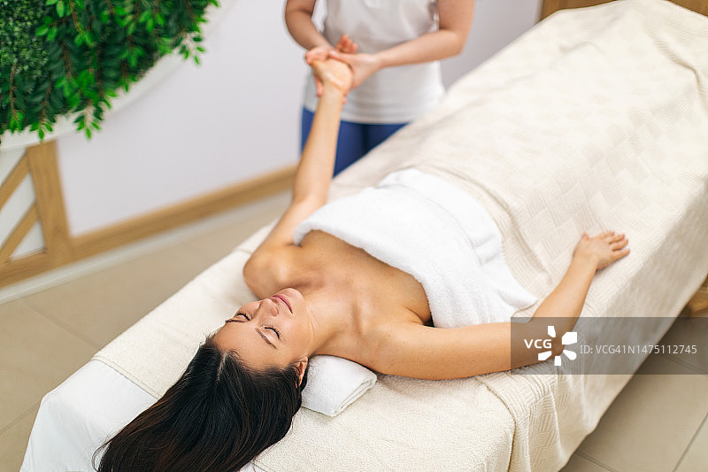 女子在水疗中心接受手臂按摩图片素材