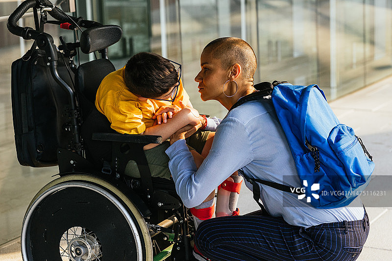 母亲安慰患有四肢瘫痪、需要轮椅出行的儿子图片素材