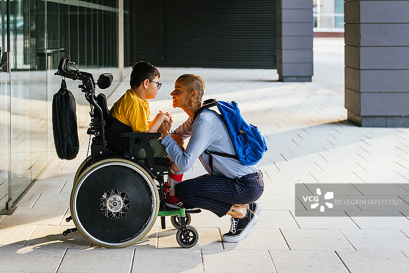 坐在轮椅上，认真听妈妈说话的儿童图片素材