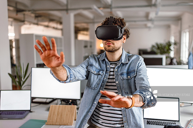 年轻人在现代办公室使用VR眼镜图片素材