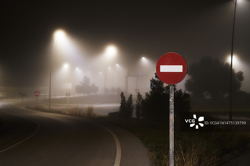 夜间雾天道路上的禁止超车标志图片素材
