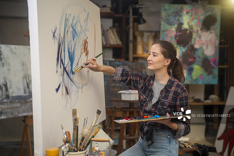 女孩在画布上作画图片素材