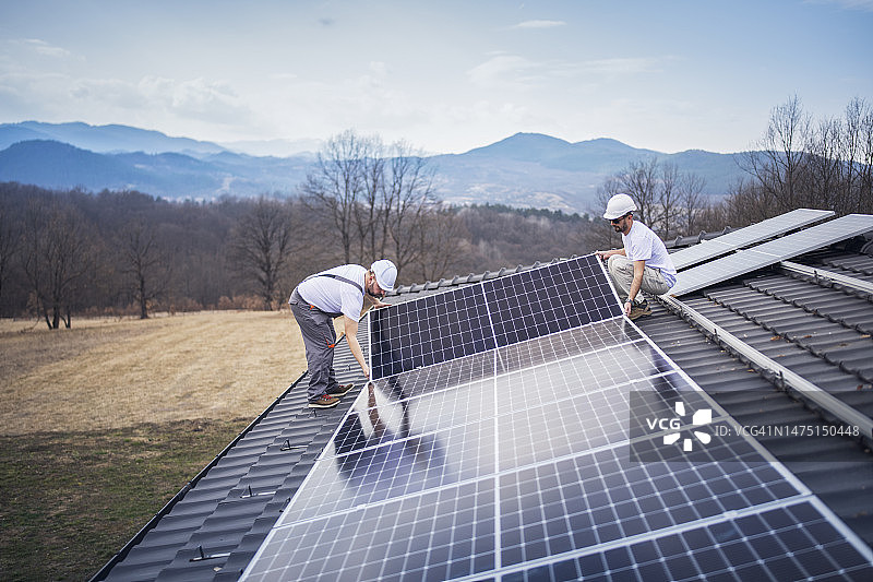 白人男子在屋顶安装面板图片素材