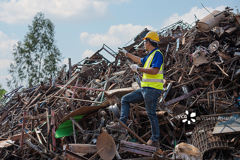 站在回收工厂废钢上的工头图片素材