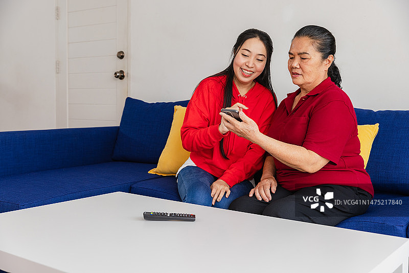 女儿教年长的女人使用手机App图片素材