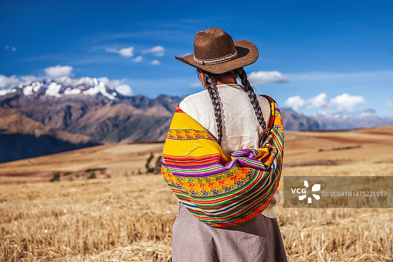 身着民族服装的秘鲁妇女眺望安第斯山脉的圣谷图片素材