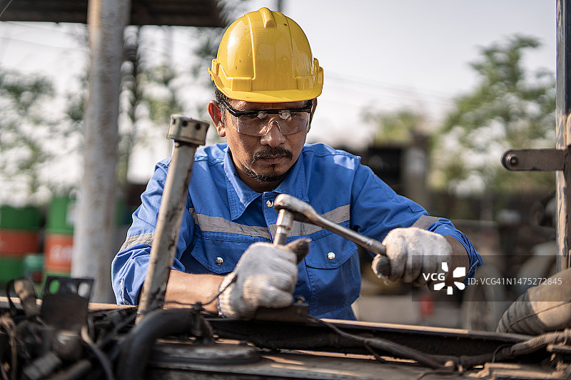 亚洲汽修工在汽车修理店修理汽车图片素材