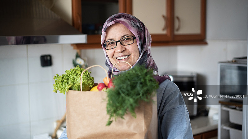 斋月购物女人，手提纸袋看向镜头图片素材