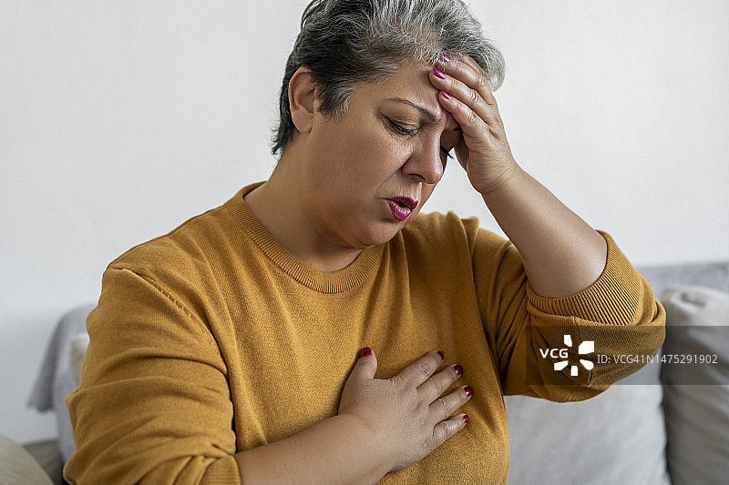 女人手捂胸口，呼吸困难图片素材