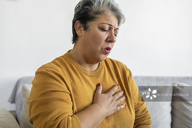 女人手捂胸口，呼吸困难图片素材